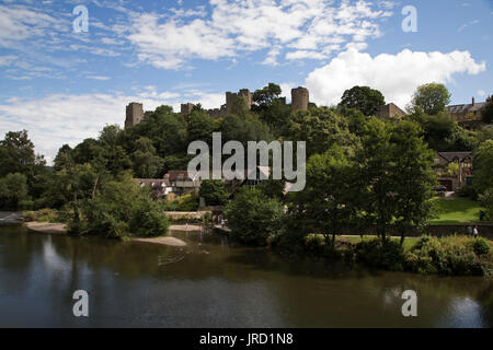 Mit Blick auf den Fluss Teme in Richtung Ludlow Castle in Ludlow, Vereinigtes Königreich. Ludlow ist eine Marktstadt in Shropshire, England. Ludlow ist mit ca. 11.000 Einwohnern die größte Stadt in South Shropshire. Die Stadt ist nahe dem Zusammenfluss der beiden Flüsse. Der älteste Teil ist der mittelalterlichen Stadtmauer, gegründet im späten 11. Jahrhundert nach der normannischen Eroberung Englands. Es dreht sich auf einem kleinen Hügel liegt am östlichen Ufer der Biegung des Flusses Teme. Auf diesem Hügel ist Ludlow Castle und die Pfarrkirche St. Laurences, die größte in der Grafschaft. Von dort die Straßen Hang downwa Stockfoto