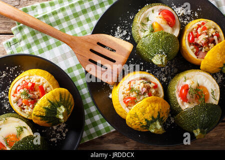 Gelbe Zucchini gebacken mit Bulgur und Fleisch und Grüne Zucchini gefüllt mit Ei und Tomaten close-up auf einem Teller. Horizontale Ansicht von oben Stockfoto