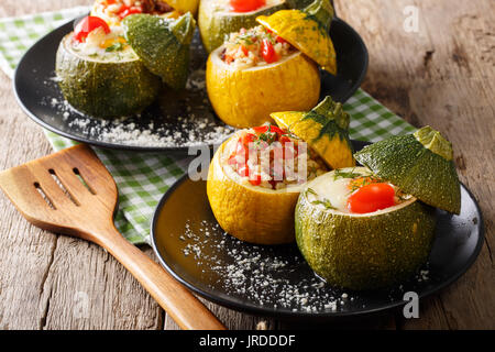 Leckere runde Zucchini gebacken mit Bulgur und Fleisch, sowie ein Ei mit Tomaten close-up auf einem Teller. Horizontale Stockfoto