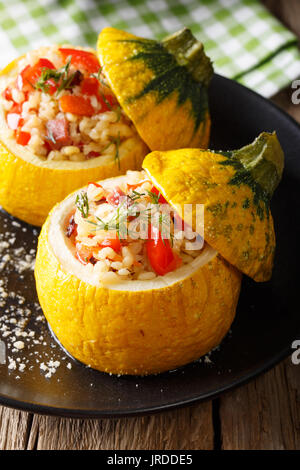 Gebackene gelben Zucchini gefüllt mit Bulgur, Fleisch und Gemüse close-up auf einem Teller. Vertikale Stockfoto