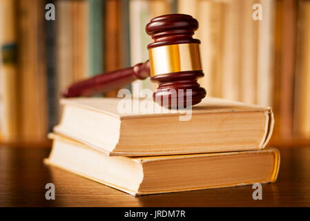 Gesetz Bücher mit Holz und Messing Richter Hammer, die auf der Oberseite auf einer hölzernen Schreibtisch, Detailansicht mit flachen dof Stockfoto