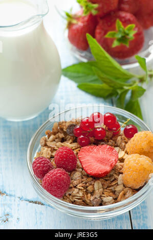 Gesundes Frühstück Müsli Müsli mit Früchten und Beeren Erdbeeren, Himbeeren und rote Johannisbeeren mit Milchprodukten. Selektive konzentrieren. Die vertikale Stockfoto