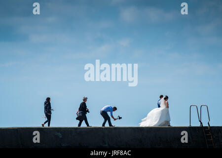 Aberystwyth Wales UK, Samstag, 5. August 2017 UK Wetter: nach einem Morgen von Starkregen und Hagel, das Wetter in Aberystwyth hat erheblich verbessert, mit einer Strecke; y verheiratet Paar posieren für Fotos und Videos in der warmen Sonne am Hafen in West Wales Resort Stadt Photo Credit: Keith Morris/Alamy Live News Stockfoto