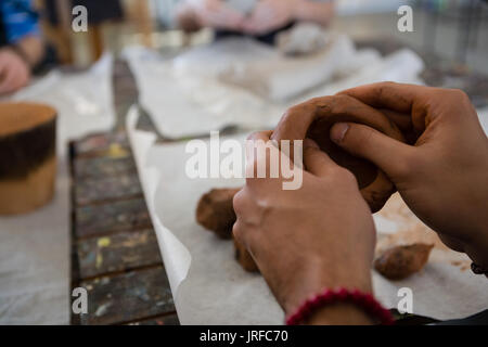 Zugeschnittenes Bild von Hand mit Ton während der Skulptur Stockfoto