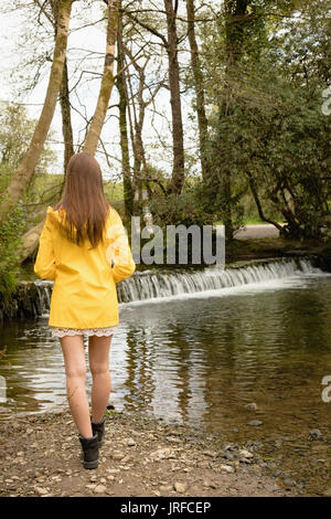 Frau, die in der Nähe von Fluss im Wald Stockfoto