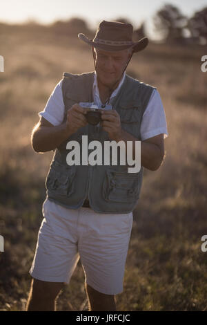 Mann überprüfung Bild auf der Kamera während der Safari Ferienhäuser Stockfoto