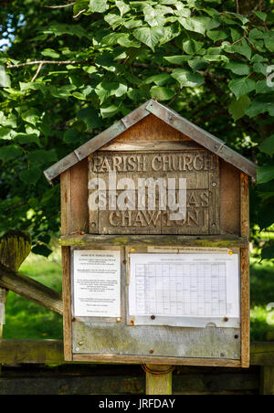 Holz- Aushang außerhalb von der Pfarrkirche St. Nikolaus, Chawton, Hampshire, Südengland, Großbritannien, Begräbnisstätte von Jane Austen's Mutter und Schwester Stockfoto