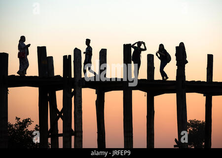 Silhouette der Reisenden bei Sonnenuntergang auf U-Bein Brücke,, Amarapura, in der Nähe von Mandalay, Myanmar. Stockfoto