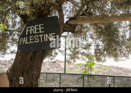 Ein Blick auf das Zentrum für die widersprüchliche Stadt Hebron von einem Palästinensischen Nachbarschaft mit Blick auf sie mit einem freien Palästina Schild an einem Baum gesehen Stockfoto