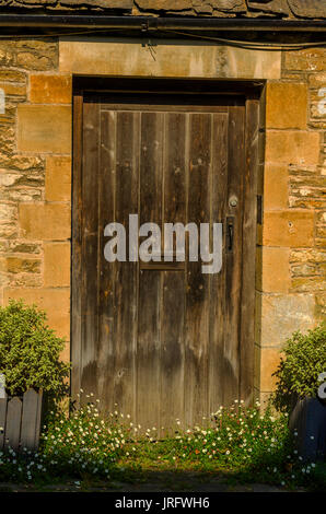 stilvolle Eintritt in ein Wohnhaus, eine interessante Fassade der alten Steinmauer, alte Holztür, typische alte englische Gebäude, Architektur Stockfoto