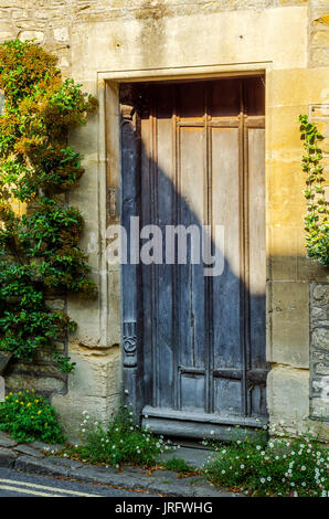 stilvolle Eintritt in ein Wohnhaus, eine interessante Fassade der alten Steinmauer, alte Holztür, typische alte englische Gebäude, Architektur Stockfoto