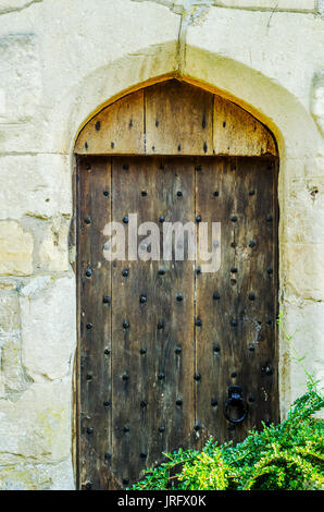 stilvolle Eintritt in ein Wohnhaus, eine interessante Fassade der alten Steinmauer, alte Holztür, typische alte englische Gebäude, Architektur Stockfoto