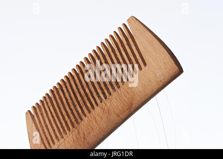 Holz- Kamm mit dunklen Haare close-up auf weißem Hintergrund Stockfoto