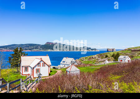 Perce, Kanada - Juni 6, 2017: Stadtbild von Bonaventure Island Park Eingang mit Häusern und grünen Wiesen, Quebec blaue Fahne mit Blick auf den Rocher Perce Stockfoto