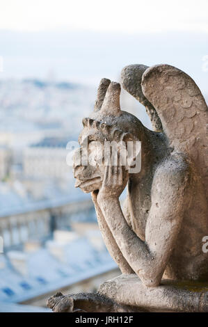 Gargoyle auf einem Pariser Dach mit der Stadt im Hintergrund Stockfoto