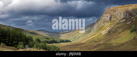 Berglandschaft, dunkle Regenwolken rolling in über sonnigen Hügel und das Tal in Wester Ross, Scottish Highlands, Schottland, UK Stockfoto