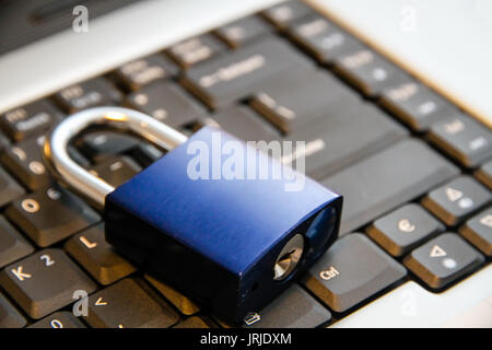 Blaues Vorhängeschloss verschlossen auf Laptop Tastatur: Bild Konzept für die Sicherheit der Daten, die gemeinsame Nutzung von Informationen, Schutz, Technologie-Verwundbarkeit. Stockfoto