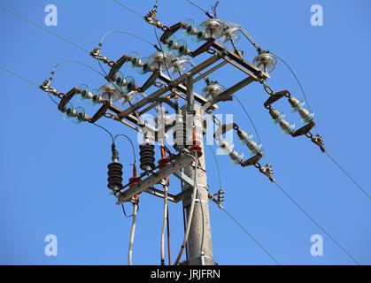 Schalter von einer hohen Spannung elektrische Leitung auf einen konkreten Pol und Hintergrund des blauen Himmels Stockfoto