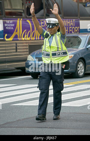 Eine attraktive Stadt New York Polizistin Regie Verkehr auf die Park Ave & East 34th Street in Manhattan, New York City. Stockfoto