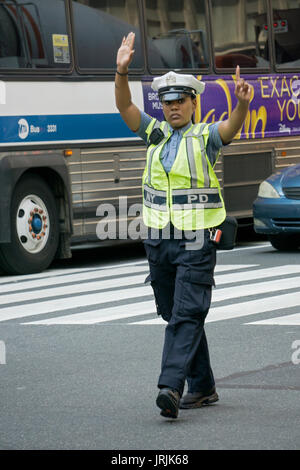 Eine attraktive Stadt New York Polizistin Regie Verkehr auf die Park Ave & East 34th Street in Manhattan, New York City. Stockfoto