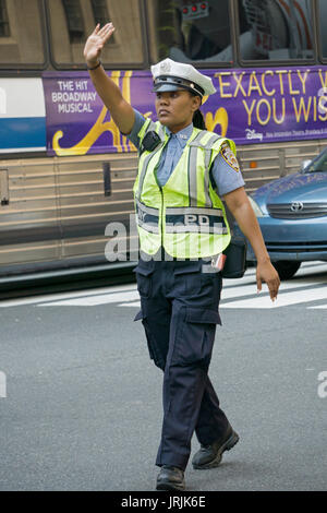Eine attraktive Stadt New York Polizistin Regie Verkehr auf die Park Ave & East 34th Street in Manhattan, New York City. Stockfoto