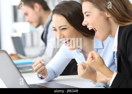 Aufgeregt Führungskräfte lesen Online News in einem Laptop im Büro Stockfoto