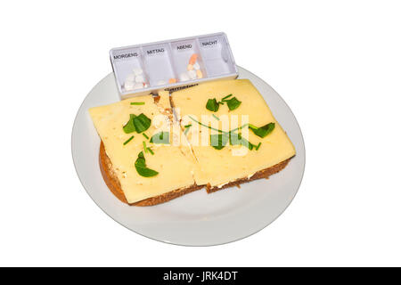 Einfacher Käse Brot mit frischen Kräutern und eine Medizin auf einer weißen Platte gegen neutralen Hintergrund. Stockfoto