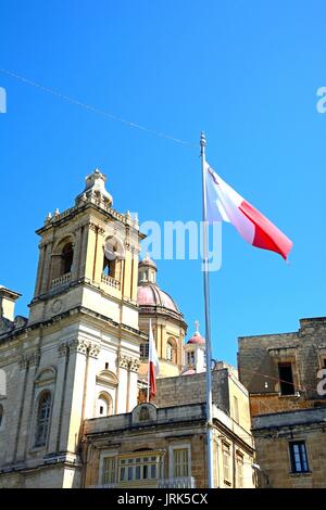 Blick auf St. Laurentius Kirche mit einem maltesischen Flagge im Vordergrund, Vittoriosa (Sibenik), Malta, Europa. Stockfoto