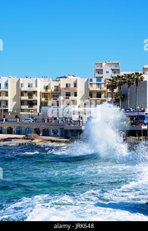 Meer auf der felsigen Küste mit einer Einkaufsstraße an der Rückseite, Bugibba, Malta, Europa. Stockfoto