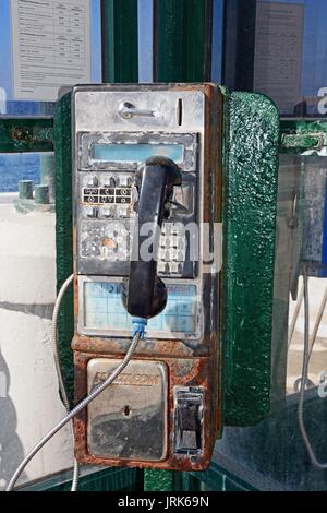 Rostige alte öffentliche Münzfernsprecher in einer Telefonzelle, Bugibba, Malta, Europa. Stockfoto