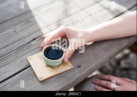Traditionelle chinesische Teezeremonie - Woman's Hand mit einem chinesischen Tee Tasse mit chinesischen Pu Erh Tee gefüllt Stockfoto