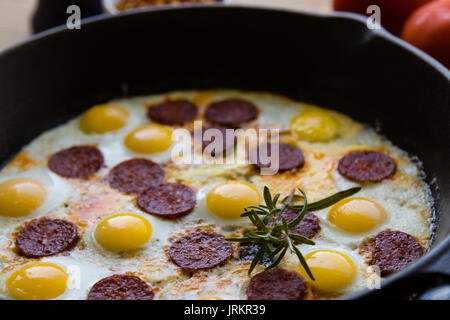 Gebratene Wachtel Eier mit Wurst in Schwarz pan Stockfoto