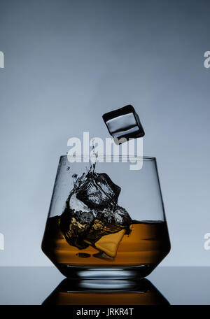 Whiskey on the rocks mit Eiswürfeln und Spritzwasser Stockfoto