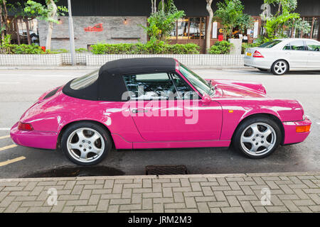 Hongkong - Juli 10, 2017: Rosa Porsche 964 Carrera 2 Cabriolet, klassischen deutschen Sportwagen steht auf der Straße in Hong Kong City, Seitenansicht Stockfoto