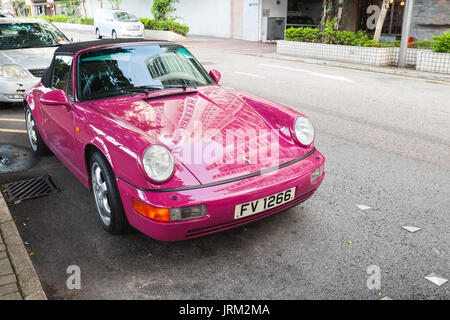 Hongkong - Juli 10, 2017: Rosa Porsche 964 Carrera 2 Cabriolet, klassischen deutschen Sportwagen steht auf der Straße in Hong Kong City Stockfoto