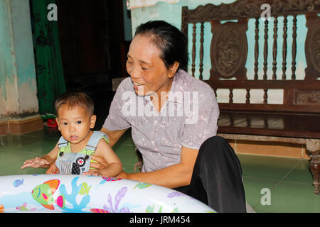 HAI DUONG, VIETNAM, AUGUST, 20.: alte Frau spielt mit Enkel am August 20, 2014 in Hai Duong, Vietnam. Stockfoto