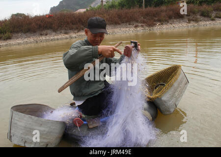 HAI DUONG, VIETNAM, Juli, 30:Fischer mit Boot und Angeln auf einem kleinen Fluss an Juli 30, 2014 in Hai Duong, Vietnam. Stockfoto