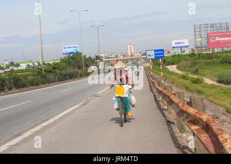 HAI DUONG, VIETNAM, AUGUST, 20.: asiatische Frau auf einem Fahrrad auf der Straße am August 20, 2014 in Hai Duong, Vietnam. Stockfoto