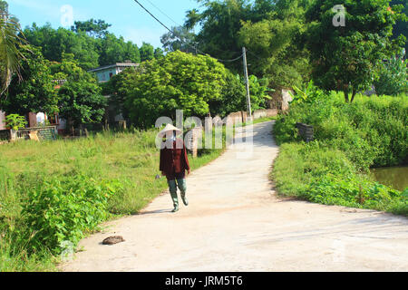 HAI DUONG, VIETNAM, AUGUST, 26.: Bäuerin mit Sichel auf der Straße am August 26, 2014 in Hai Duong, Vietnam Stockfoto