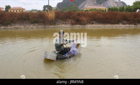 HAI DUONG, VIETNAM, Juli, 30:Fischer mit Boot und Angeln auf einem kleinen Fluss an Juli 30, 2014 in Hai Duong, Vietnam. Stockfoto