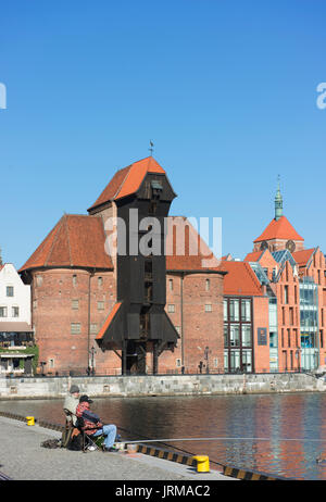 Fischer versuchen ihr Glück auf dem Kanal in der Danziger Altstadt mit der Danziger mittelalterliche Krantor im Hintergrund. Stockfoto