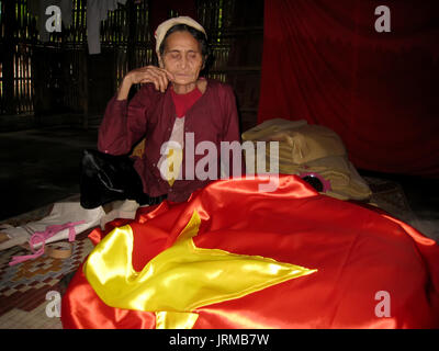 HAI DUONG, VIETNAM, September 20: alte Frau und der rote Fahne in Ihrem Haus auf September 20, 2013 in Hai Duong, Vietnam Stockfoto