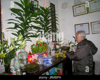 HAI DUONG, VIETNAM, Februar 07: Asiatische alter Mann mit Reis Kuchen zu Vorfahren am Neujahrstag am Februar 07, 2013 in Hai Duong, Vietnam. Dies ist eine Stockfoto