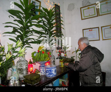 HAI DUONG, VIETNAM, Februar 07: Asiatische alter Mann mit Reis Kuchen zu Vorfahren am Neujahrstag am Februar 07, 2013 in Hai Duong, Vietnam. Dies ist eine Stockfoto