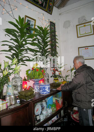 HAI DUONG, VIETNAM, Februar 07: Asiatische alter Mann mit Reis Kuchen zu Vorfahren am Neujahrstag am Februar 07, 2013 in Hai Duong, Vietnam. Dies ist eine Stockfoto
