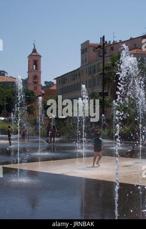 Kinder planschen in Wasserfontänen am Massena-Platz, Nizza, Frankreich Stockfoto