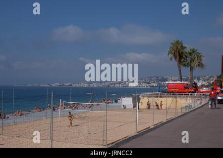 Blick auf Beach-Volleyball-Platz und Touristen am Strand, Nizza, Frankreich Stockfoto