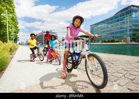 Portrait von Alter - unterschiedliche afrikanische Kinder Fahrrad eine nach der anderen auf Radweg in der Stadt Stockfoto