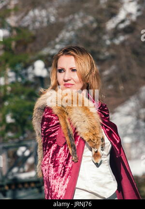 Schöne blonde Frau in Winterkleidung im Park Stockfoto