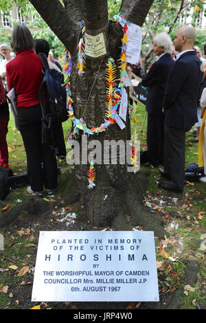 London, UK. 6. August 2017. Die Gedenkstätte Kirsche Baum am Tavistock Square während der Kampagne für nukleare Abrüstung jährliche Gedenken an die Atombombenabwürfe auf Hiroshima, Japan am Tavistock Square, London, Vereinigtes Königreich.   Der Baum wurde 1967 in Gedenken an die Opfer der Bombardierung von Camden Rat auf dem Platz gepflanzt. Seither hat eine jährliche Zeremonie um den Baum zu erinnern, den Angriff statt.  Der Angriff fand am 08:15, 6. August 1945, als die Bomber Enola Gay Boeing b-29 Superfortress die Atombombe "Little Boy", dem ersten Gebrauch der Waffe in der Geschichte fiel. Kredit Stockfoto